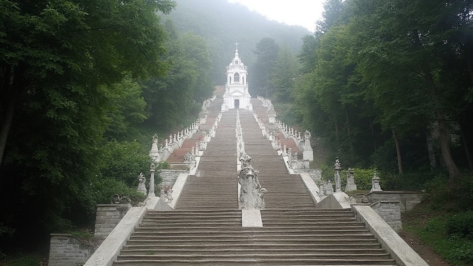 Bom Jesus do Monte baroque double-helix granite stairway climbing the wooded hill to the white sanctuary church, Braga